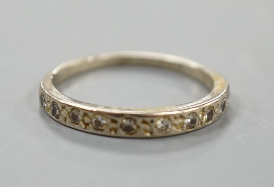 A white metal and diamond chip set half eternity ring, size K